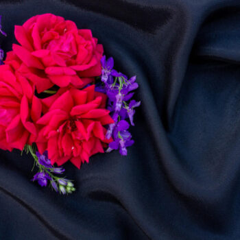 rosebuds with blue flowers black background flower arrangement flat lay place text copy space